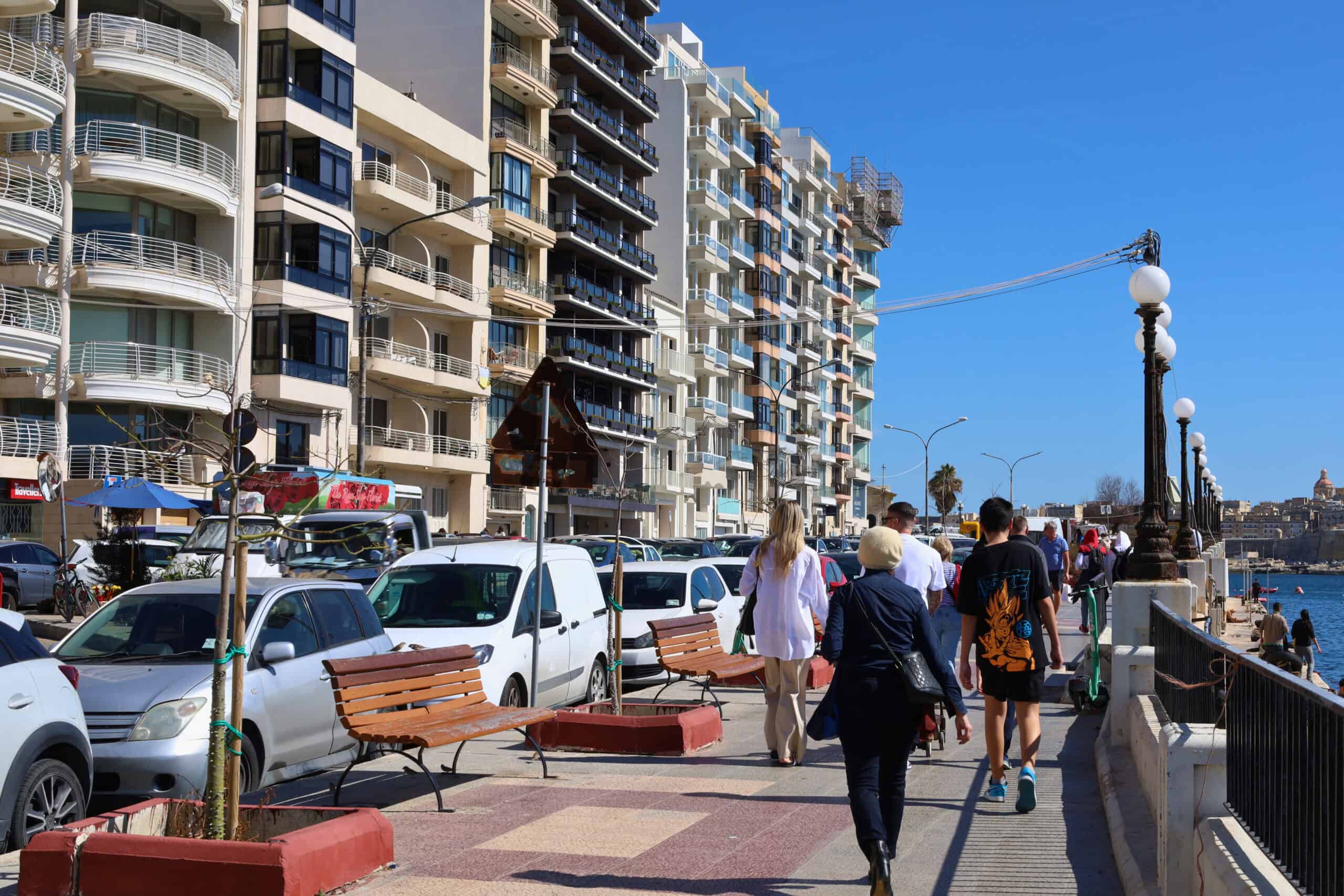 Row of tall apartment buildings along a busy street in Sliema, Malta
