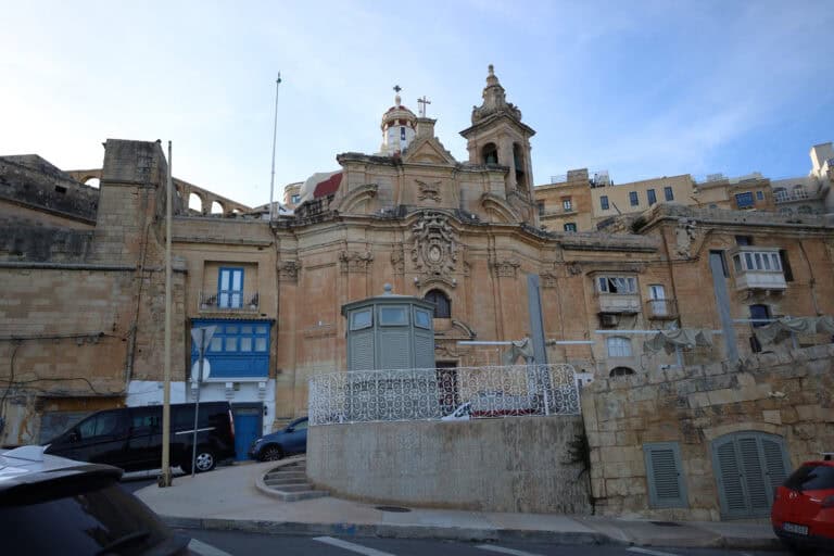 Ornate Baroque church building with stone statues in Malta