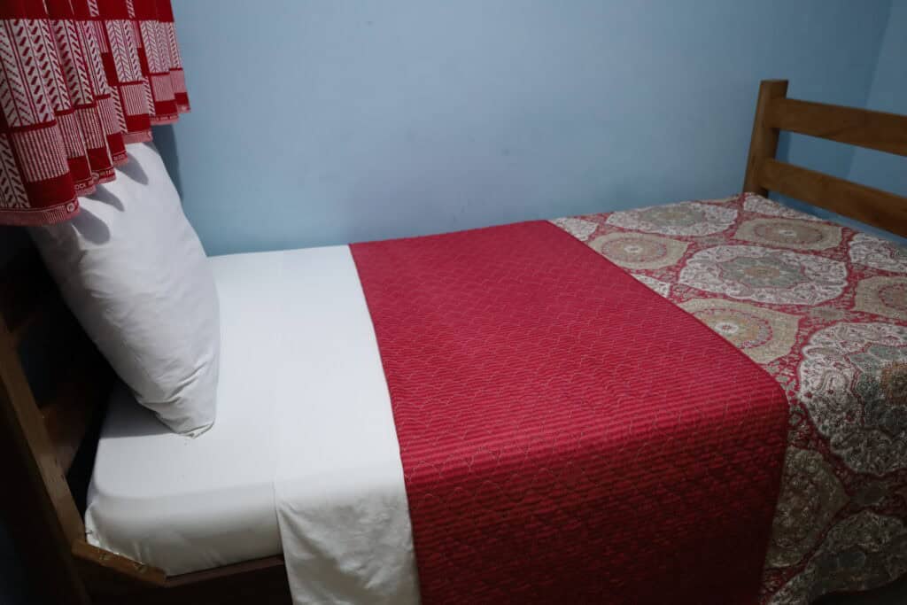Bed close-up at Sharpnet Guest House budget room in Accra.