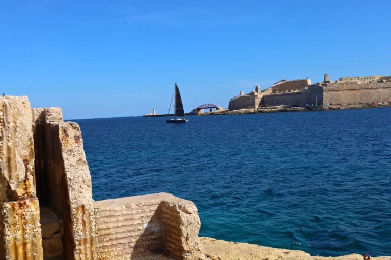Sailboat passing near a historic fort on the Malta coastline