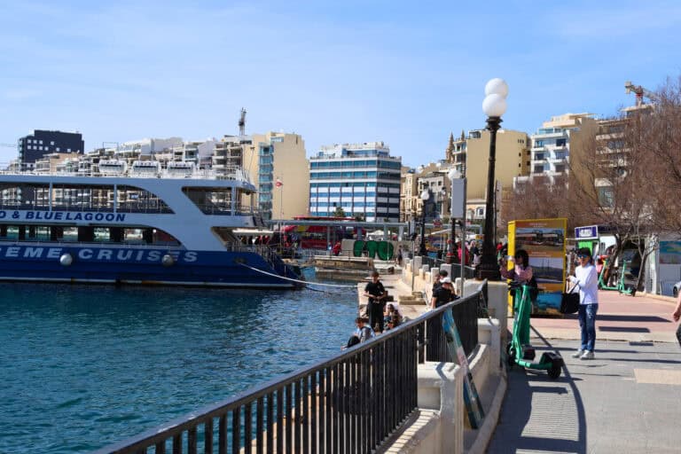 : Blue ferry boat docked at the Sliema waterfront in Malta