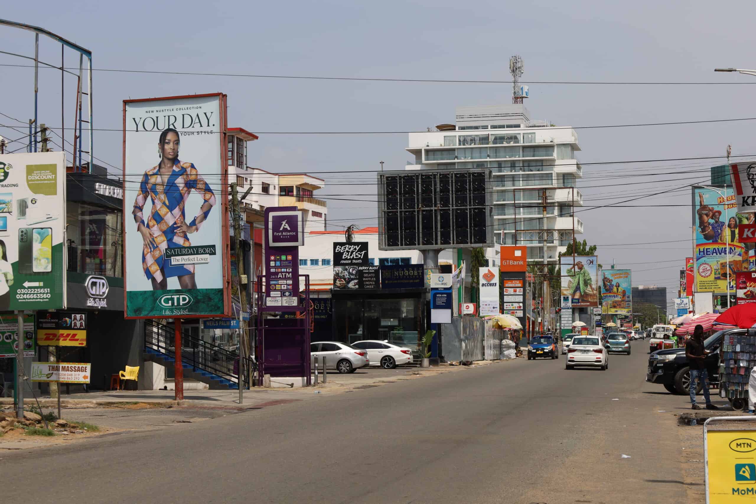 Cityscape view of Oxford Street with tall buildings and advertisements in Osu, Accra.