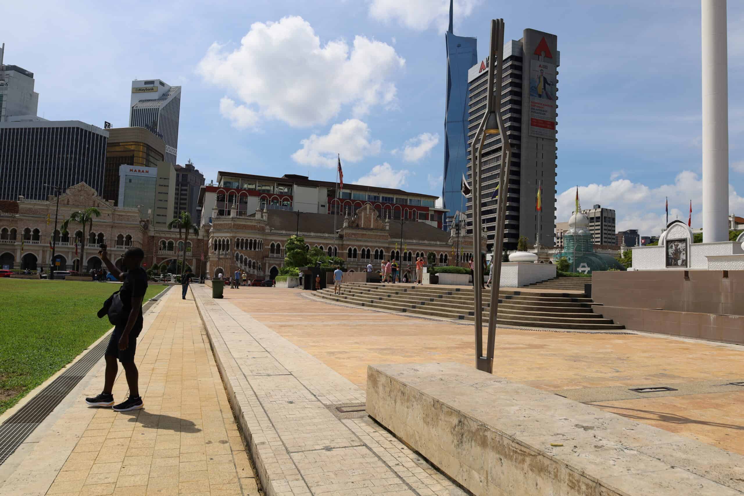 Man walking past historic buildings at Dataran Merdeka in Kuala Lumpur