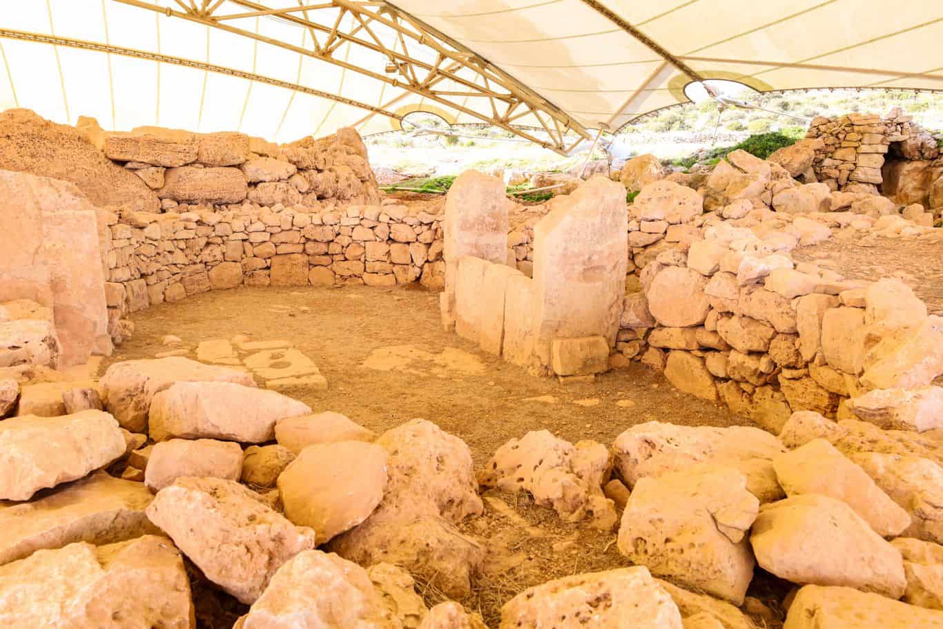 Inside view of the Mnajdra temple ruins with circular stone arrangements.