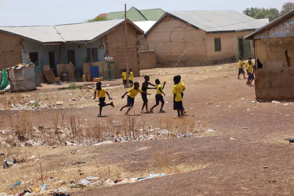 Kids playing in dusty field in Tamale, Ghana.