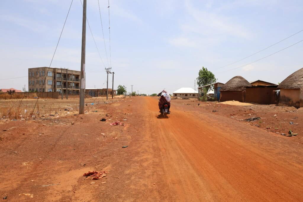 Pedestrian on dirt road in Tamale, Ghana.