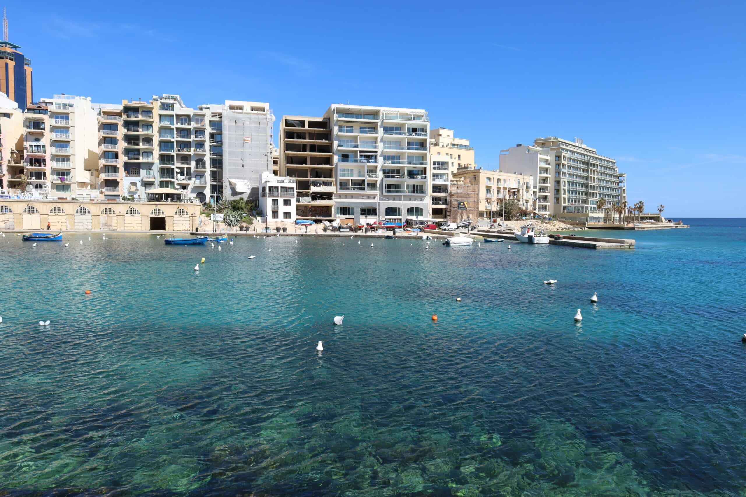 Waterfront buildings in Sliema reflecting on the clear blue sea in Malta