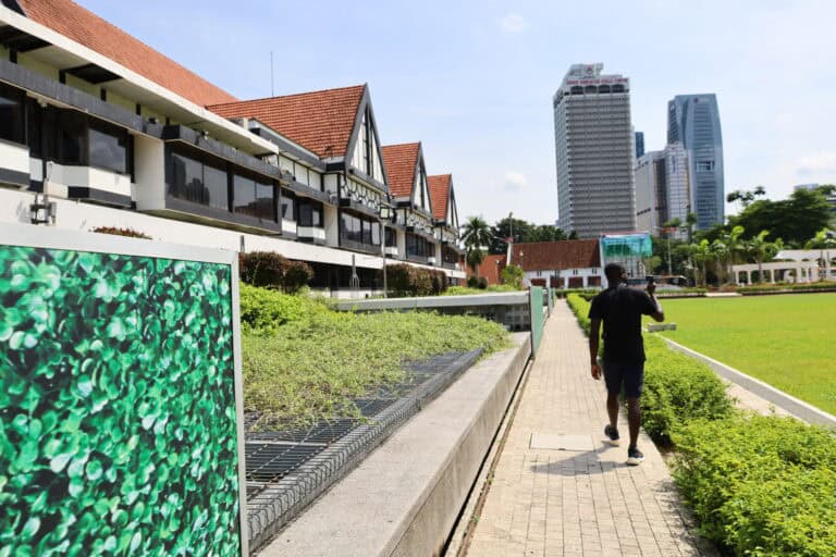 Pedestrian walking along the modern tiled pathway outside Masjid Negara