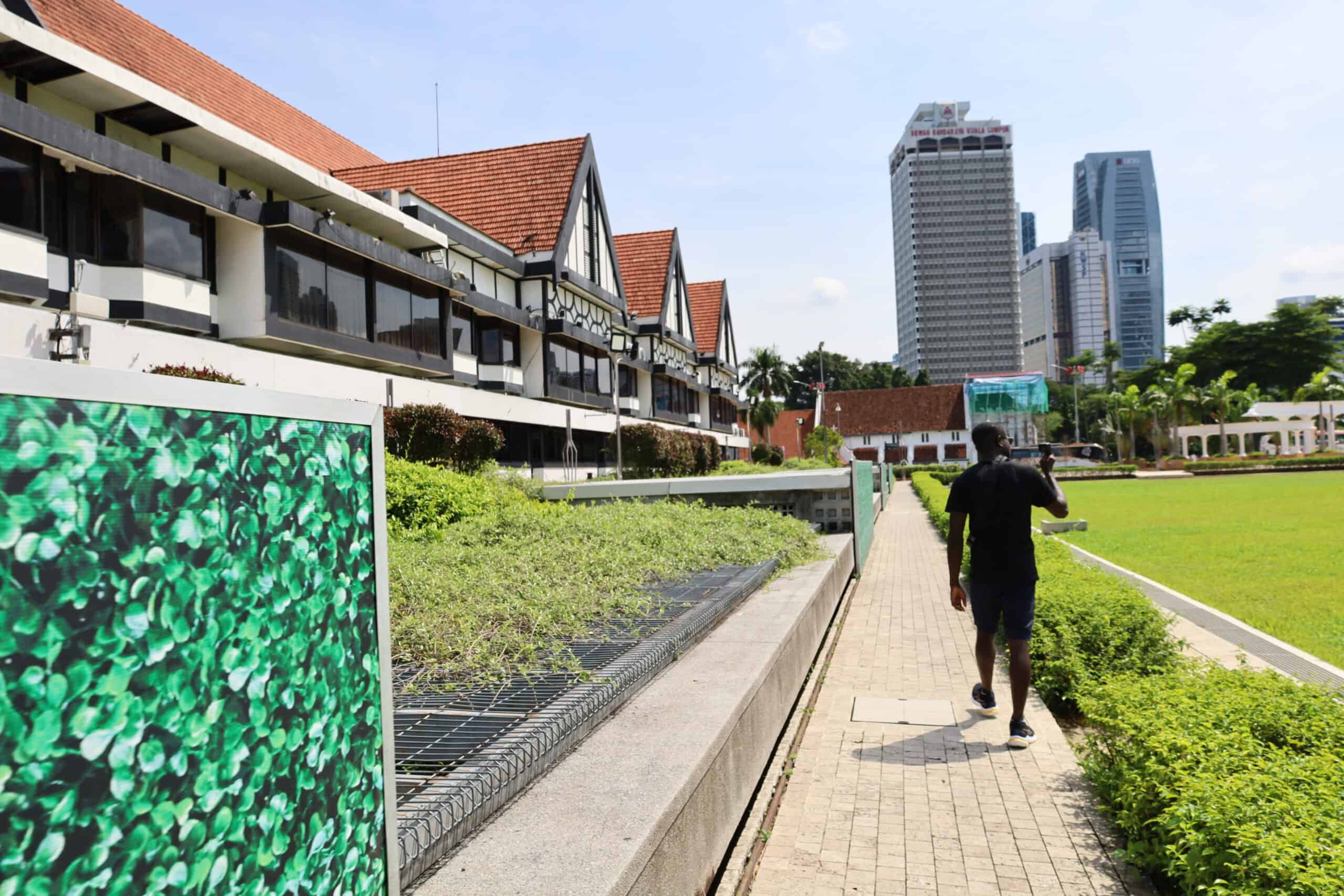 Pedestrian walking along the modern tiled pathway outside Masjid Negara
