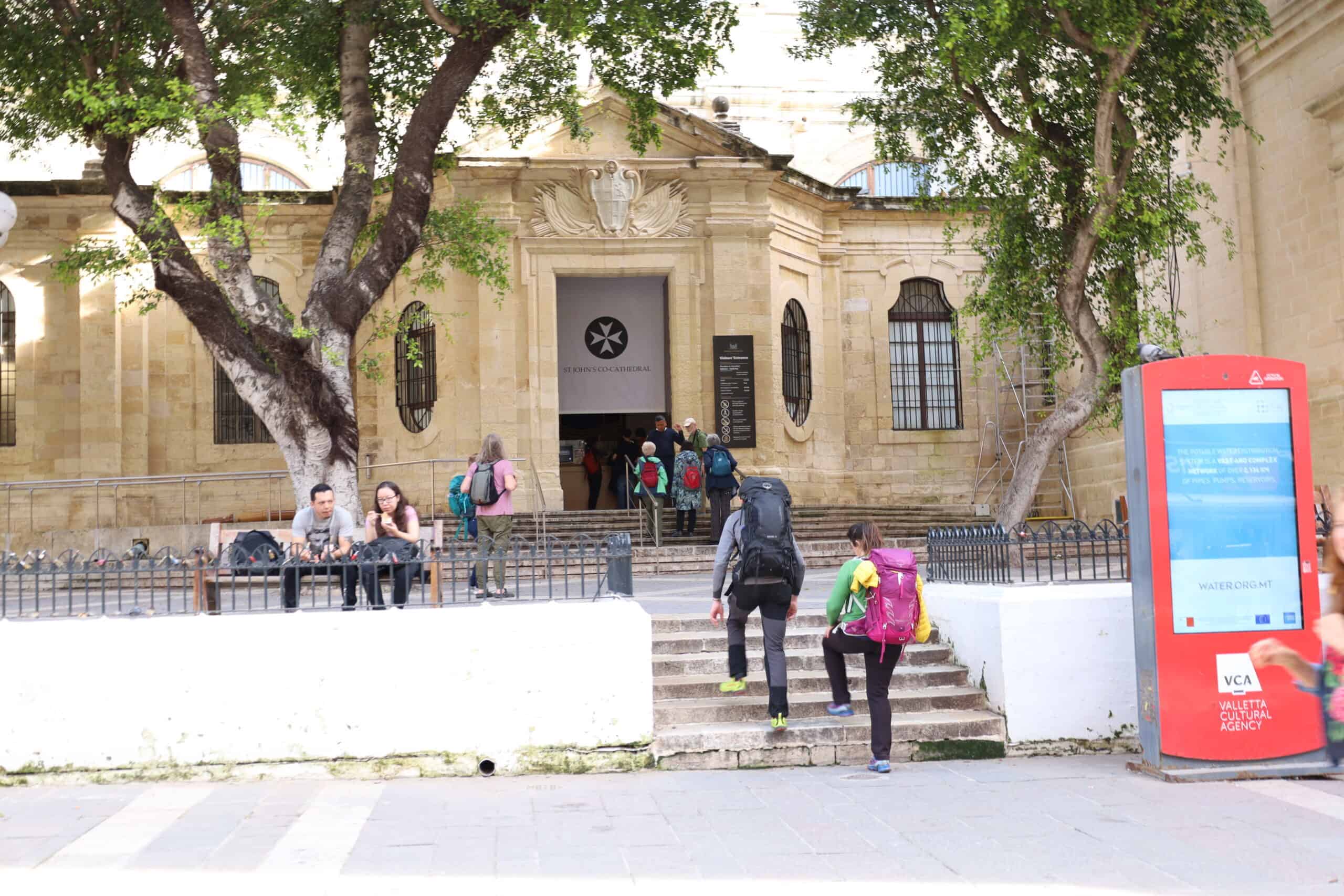 People relaxing on a bench near the postal museum in Valletta