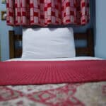 Pillow and curtains inside Sharpnet Guest House budget room in Accra.