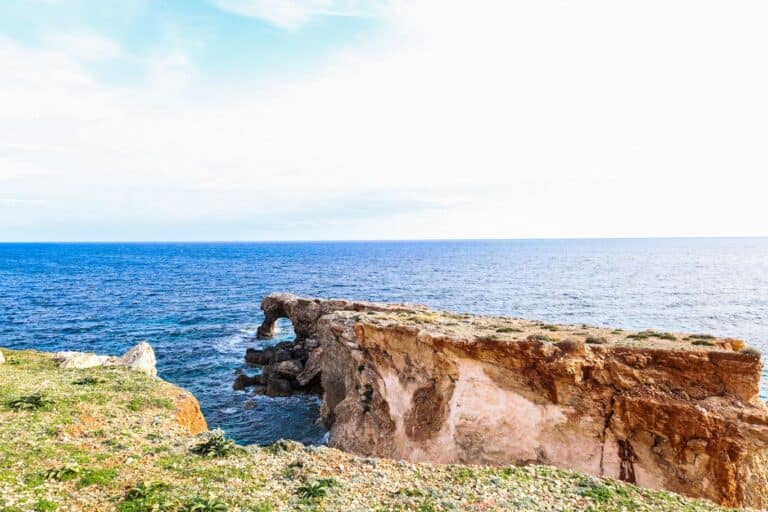 Natural stone arch formation on the rugged coastline of Qrendi, Malta.