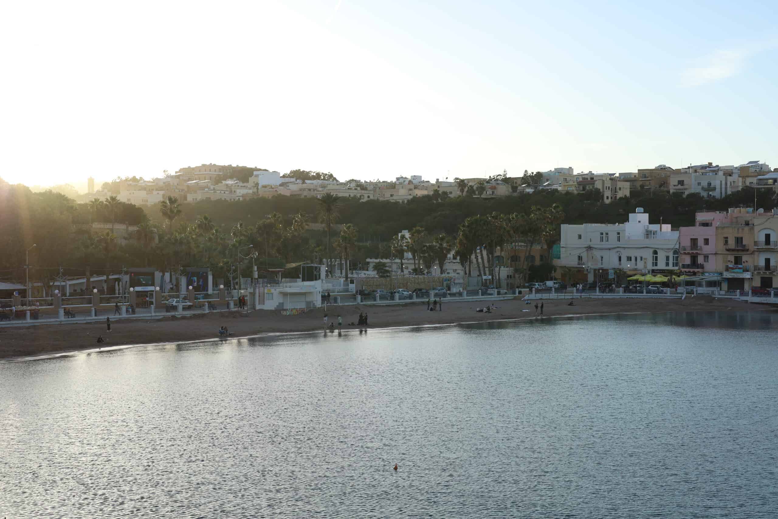 Seaside houses lit by the golden sunset in a Malta town