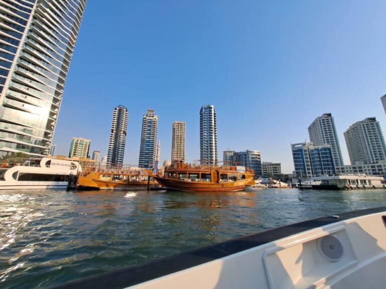 A traditional wooden dhow boat sailing in Dubai Marina