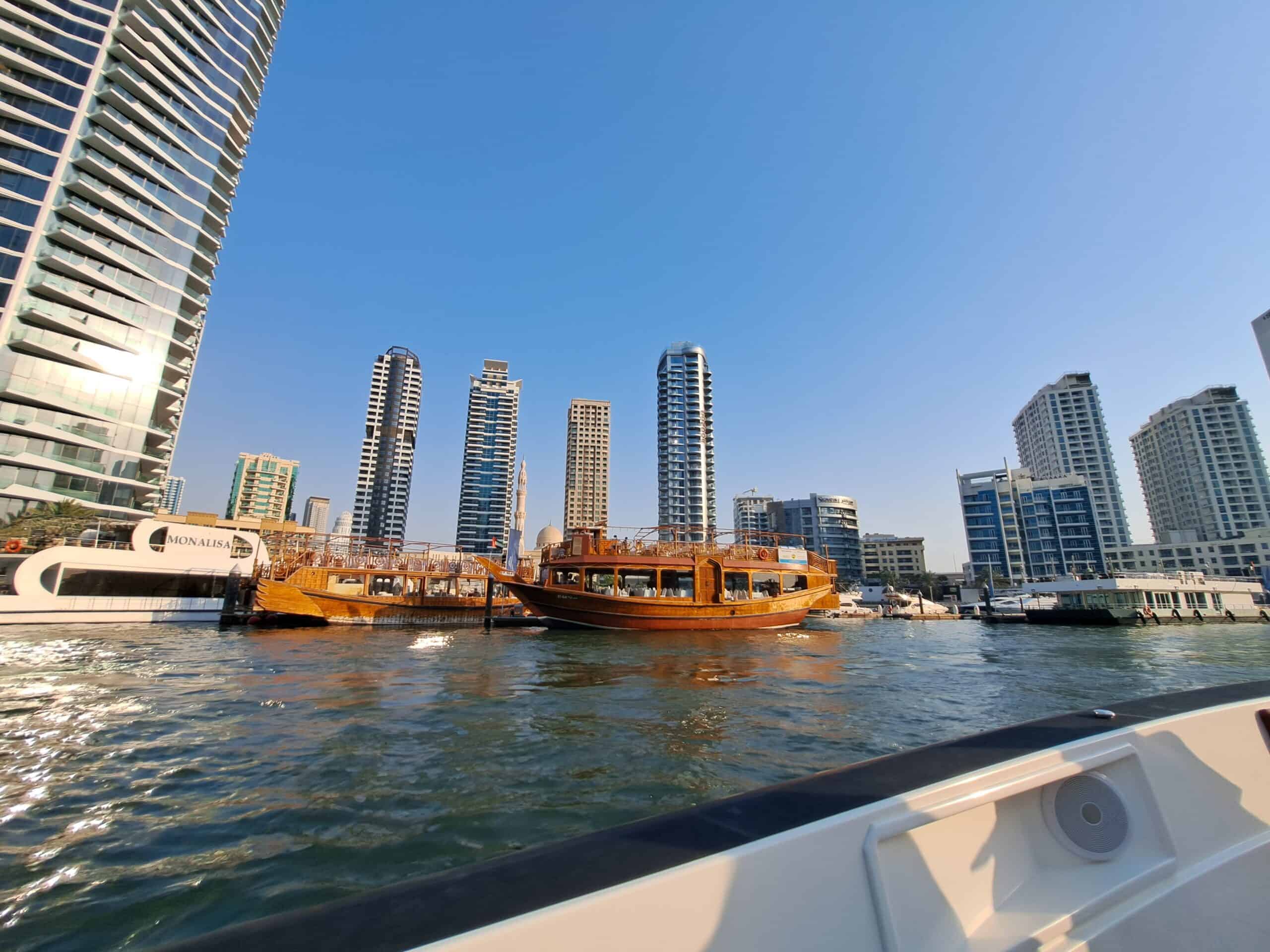 A traditional wooden dhow boat sailing in Dubai Marina