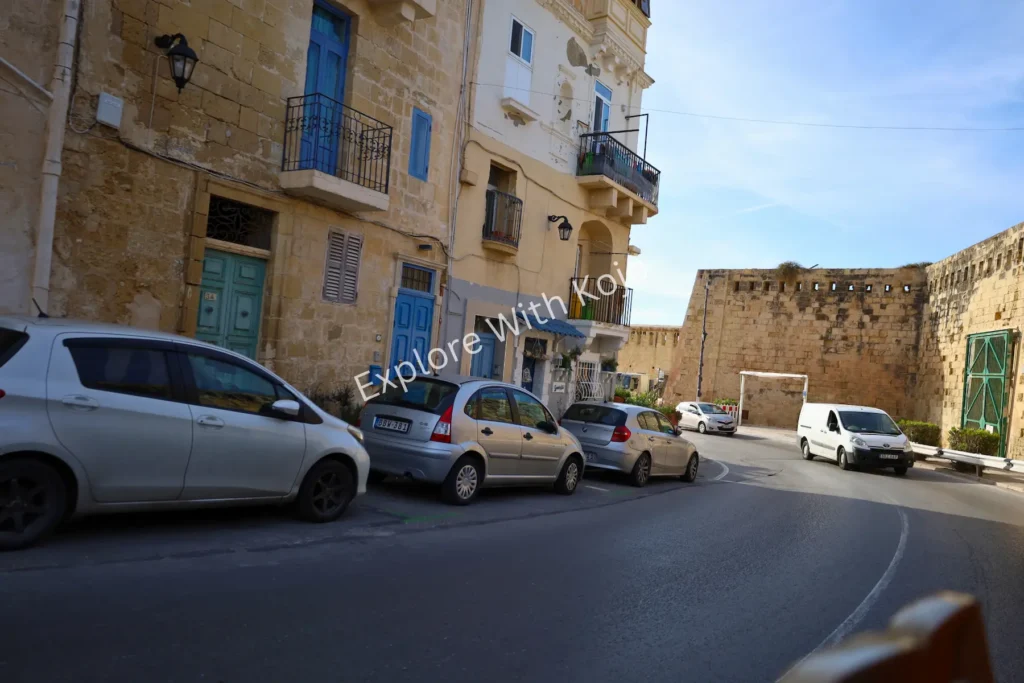 Cars parked next to limestone buildings on a street in Valletta,&nbsp;Malta.