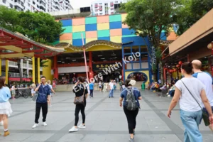 Tourists walking near colorful entrance Chinatown Singapore.