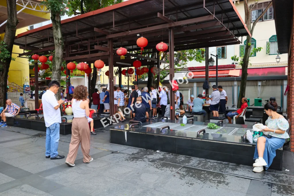 People gathering under lanterns at Chinatown Pavilion, Singapore.