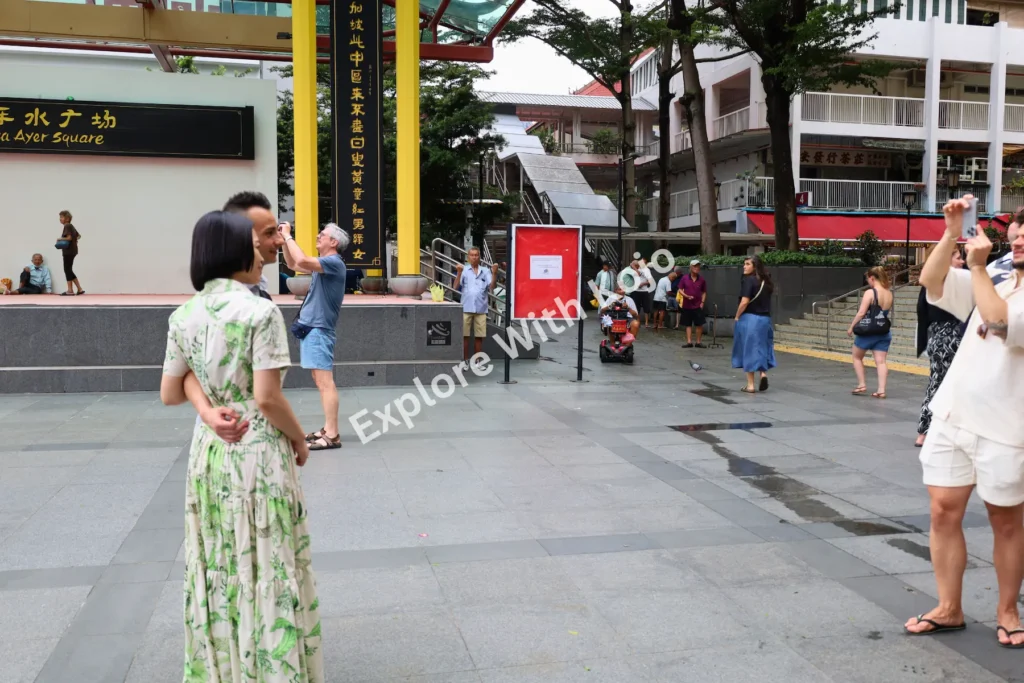 Tourists walking and taking photos in Chinatown Singapore.