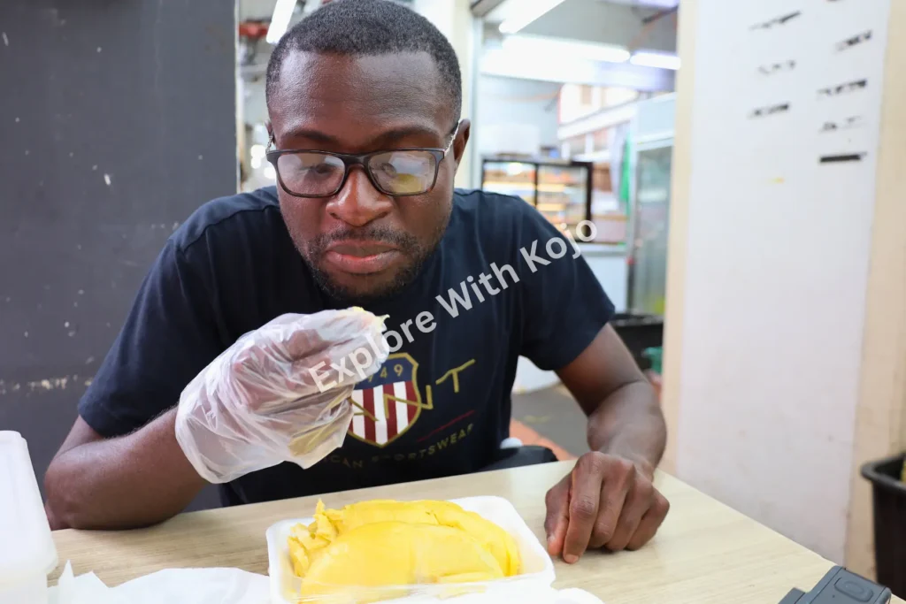 Man eating durian at a hawker center in Chinatown Singapore.