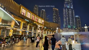 People enjoying nightlife near Dubai Mall with Emaar Tower in the background - a typical scene during ladies' nights in Dubai