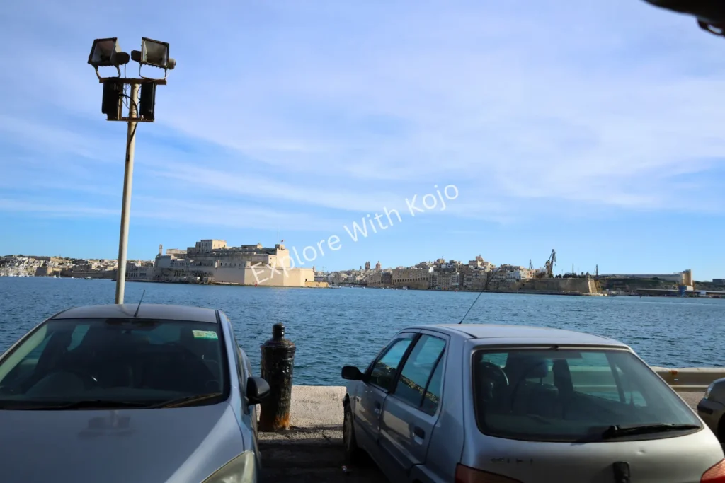 Malta harbor view with parked cars along the road.