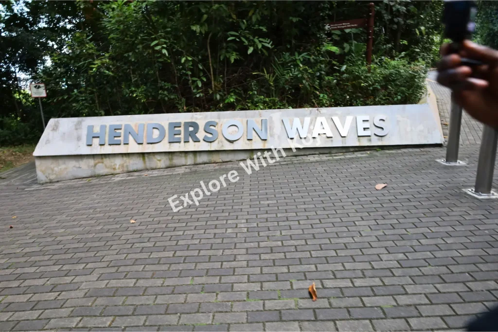 Entrance sign of Henderson Waves bridge in Singapore, surrounded by greenery.