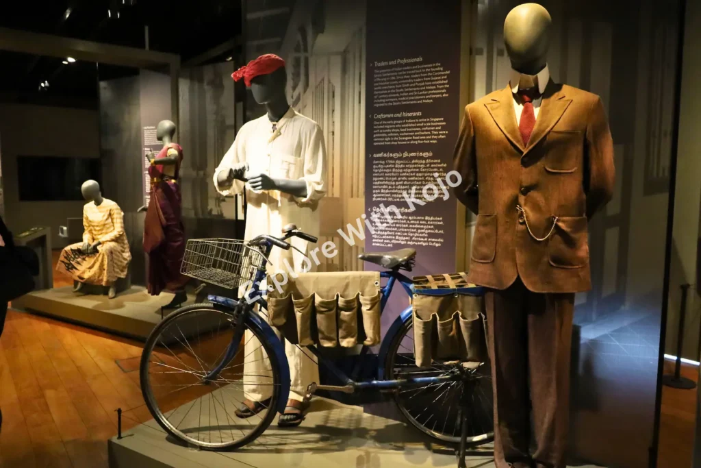 Display of mannequins in traditional attire and a bicycle at the Indian Heritage Centre in Singapore