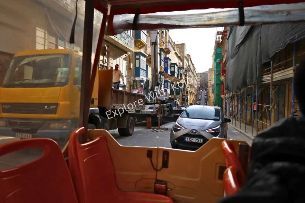 Street view of Valletta taken from inside a hop-on hop-off tour bus, Malta.