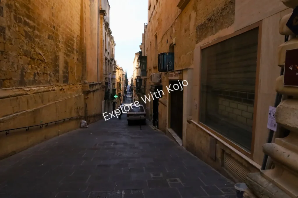 Narrow limestone alley with pedestrians&nbsp;in&nbsp;Malta.