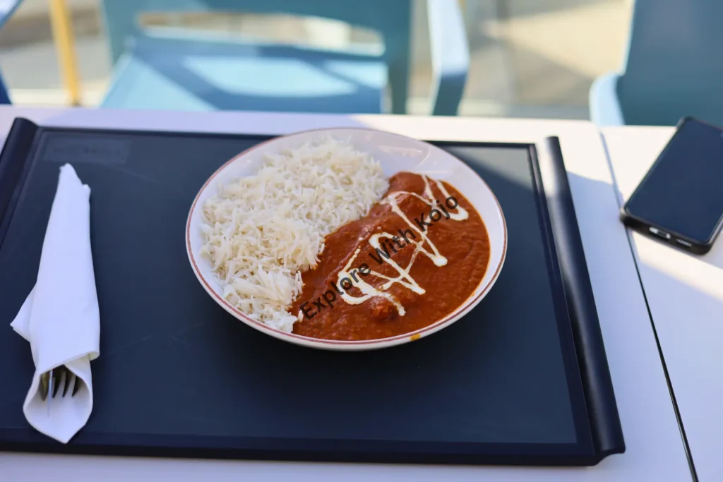 Plate of Indian butter chicken and rice at a restaurant in Malta.