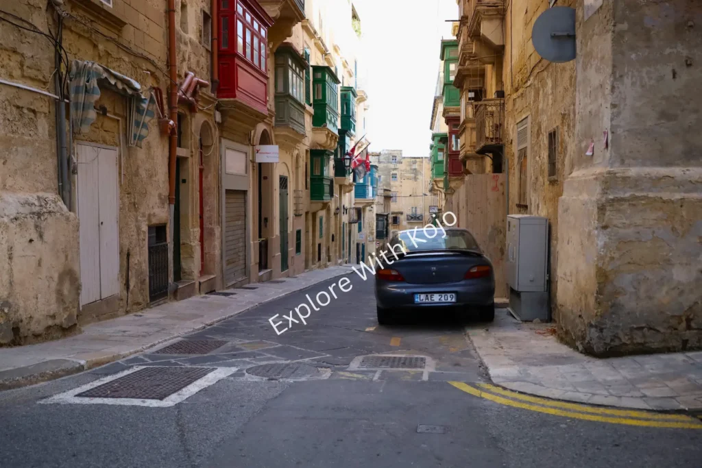 Limestone street with small shops and balconies in Malta.