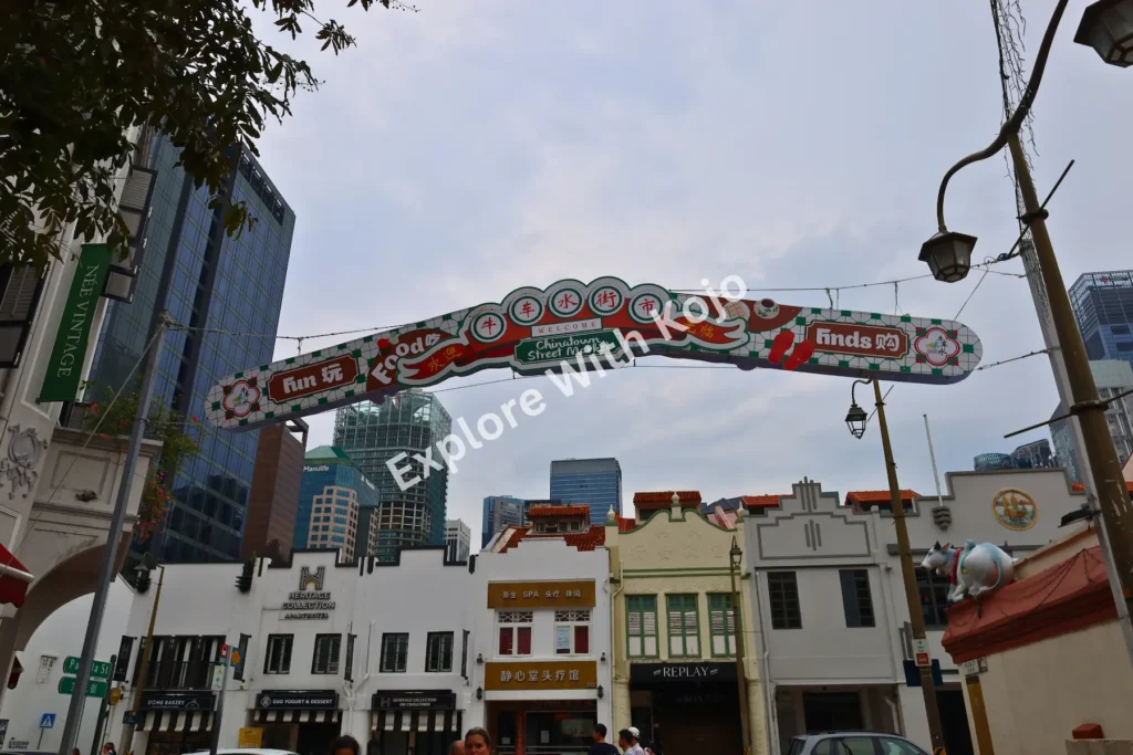 Chinatown entrance arch in Singapore with traditional shophouses in the background.