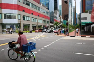 Cyclist riding along a busy Singapore street.