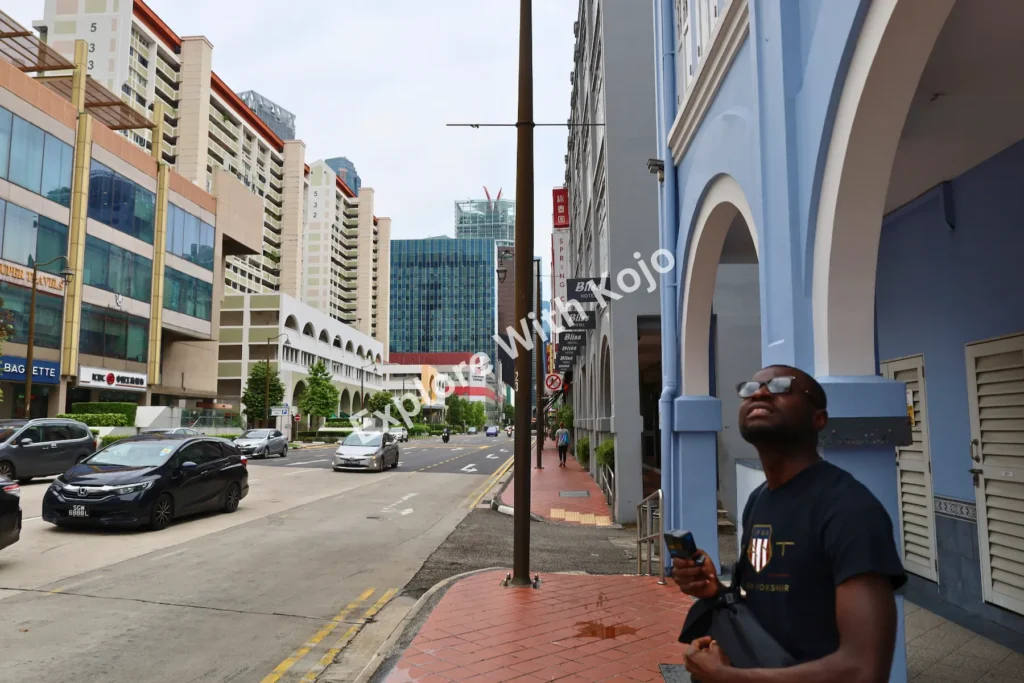Man looking up at Singapore&rsquo;s colorful buildings in Chinatown.