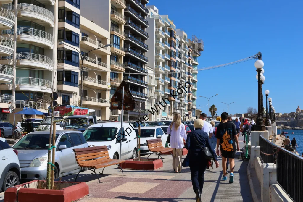 People walking along promenade in Sliema, Malta.