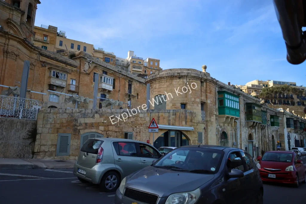 Stone buildings and parked vehicles Malta.