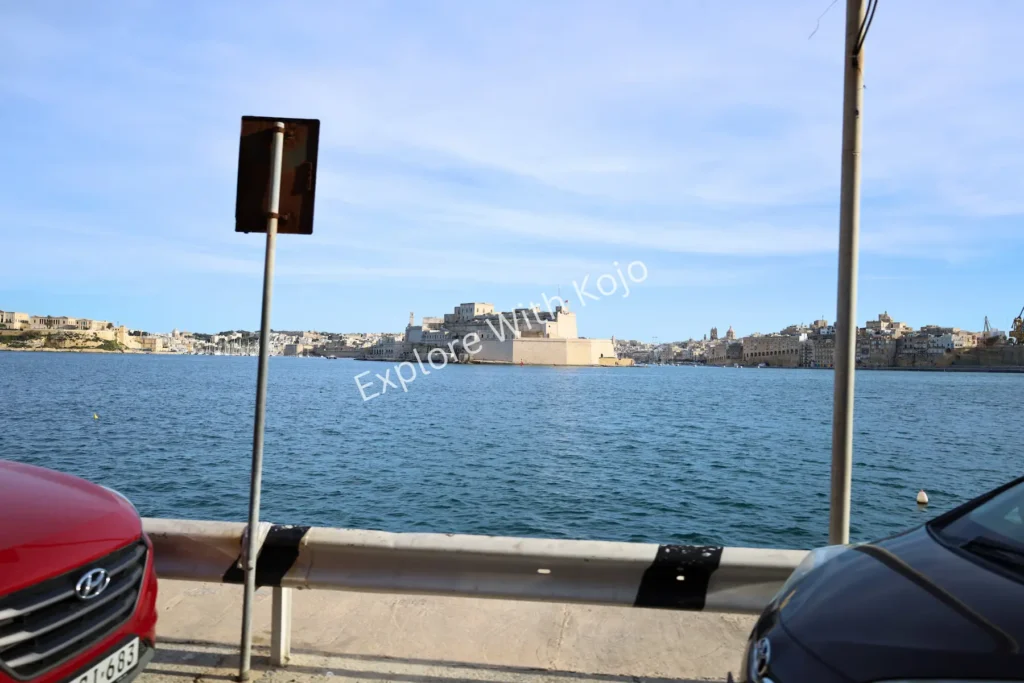 Parked cars with scenic harbor view in Malta.