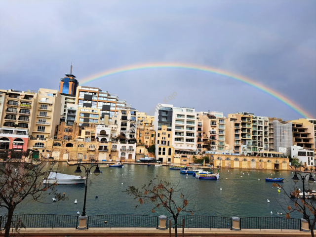 Rainbow over modern apartment buildings in Malta