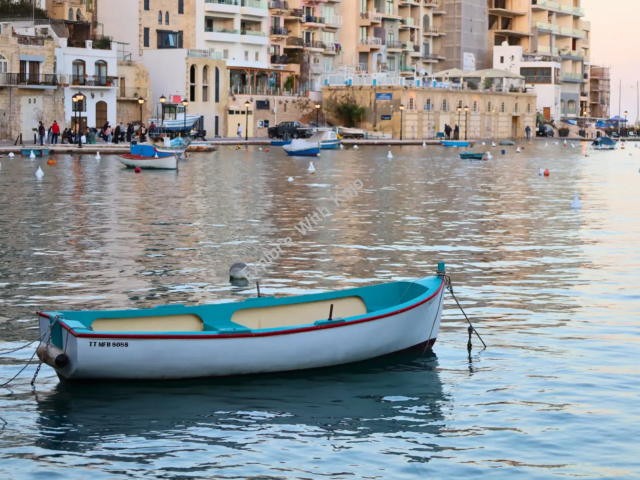 Small traditional boat floating on calm blue waters in Malta