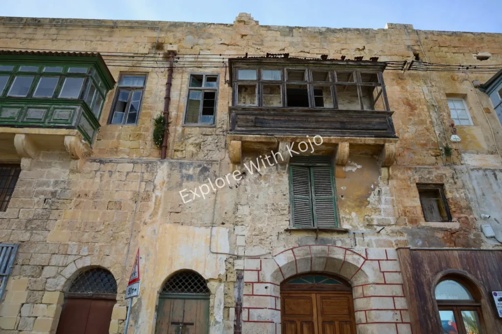 Weathered balconies on stone building in Malta.