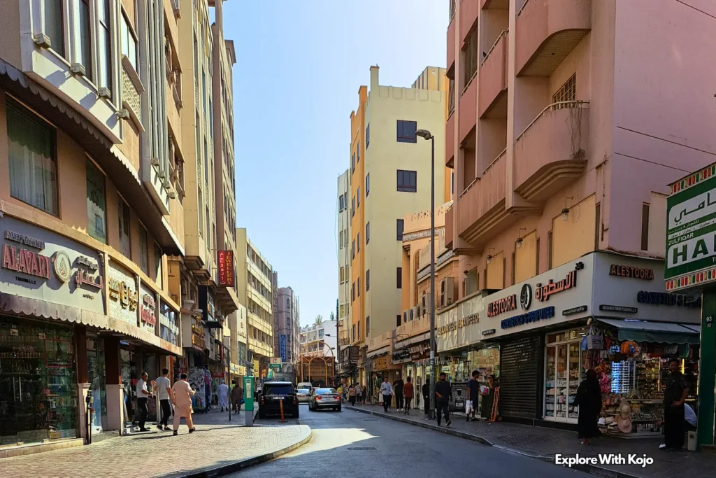 Busy street in Dubai’s old town with shops and people walking, reflecting how even traditional markets will adapt to the city’s cashless future by 2026.