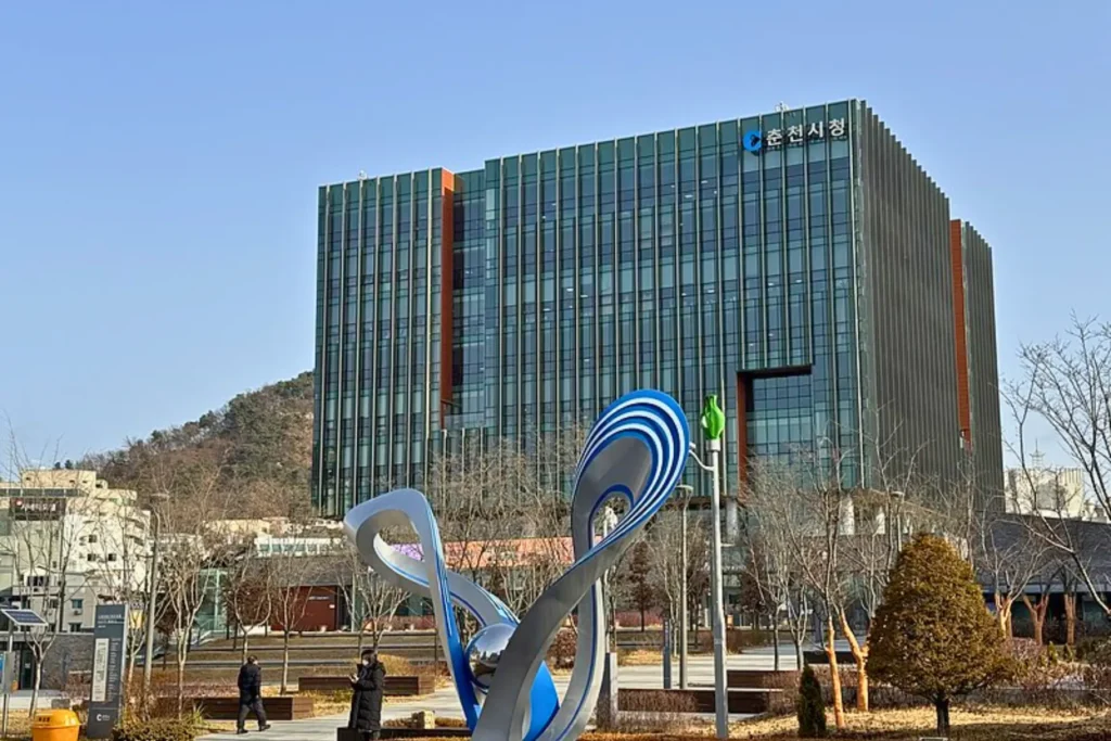 Modern building in Chuncheon with mountains in the background.