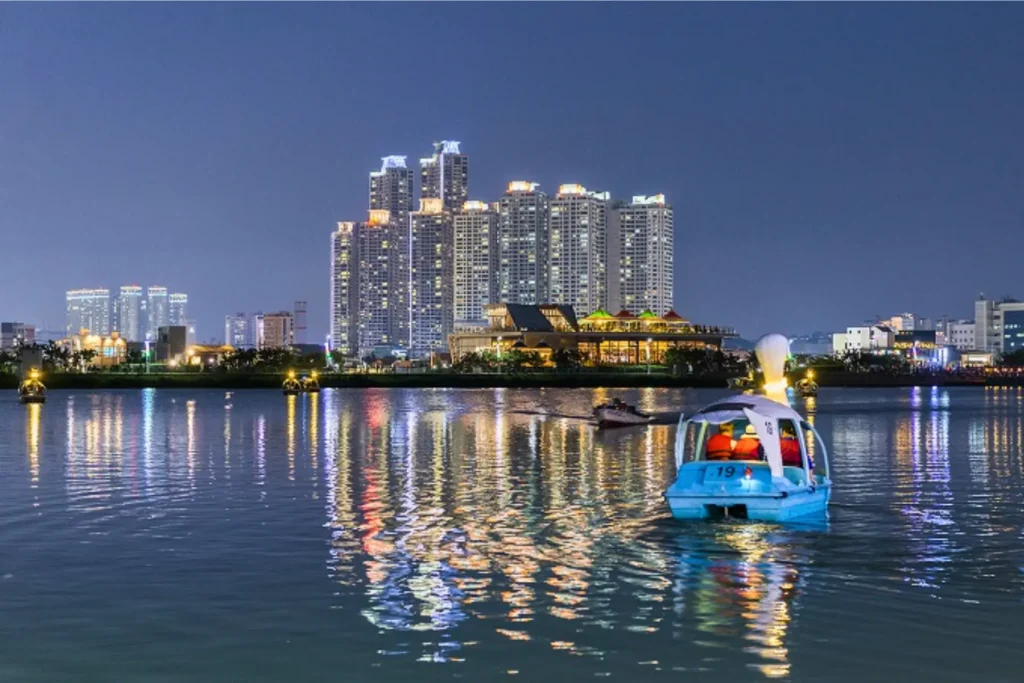 Night view of Daegu city skyline reflected on water.
