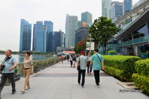 Marina Bay waterfront in Singapore with people walking and the modern skyline in the background.
