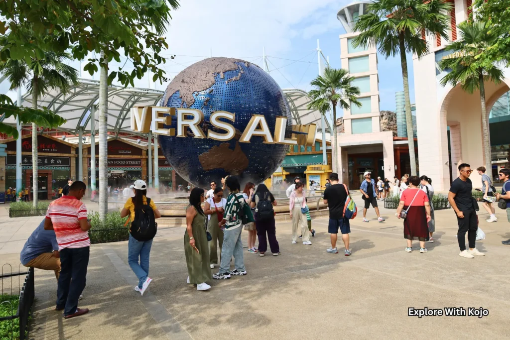 Tourists gathered at the entrance of Universal Studios Singapore with the iconic globe.