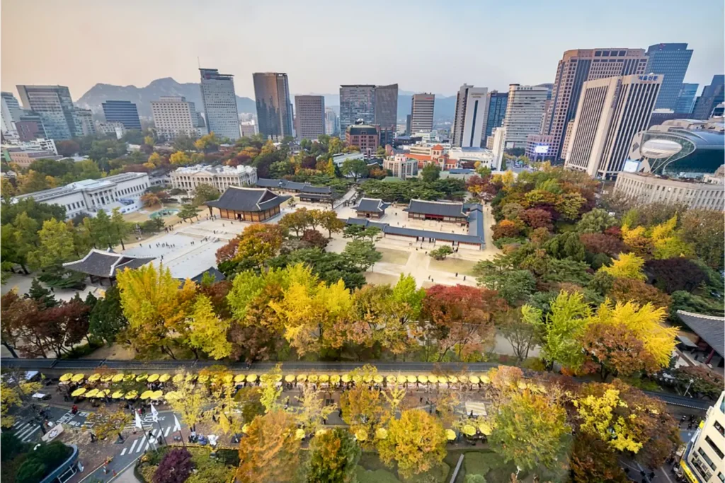 Panoramic view of Seoul city with trees and skyscrapers.
