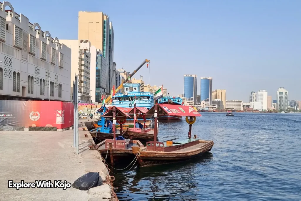 raditional wooden abra boat on Dubai Creek with city skyline in the background