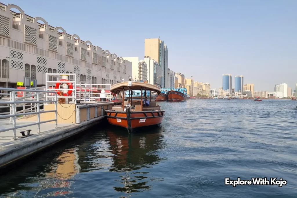 Abra water taxi docked at Dubai Creek station with modern skyline view