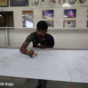 Artist drawing wax outlines on fabric in Kuala Lumpur batik workshop